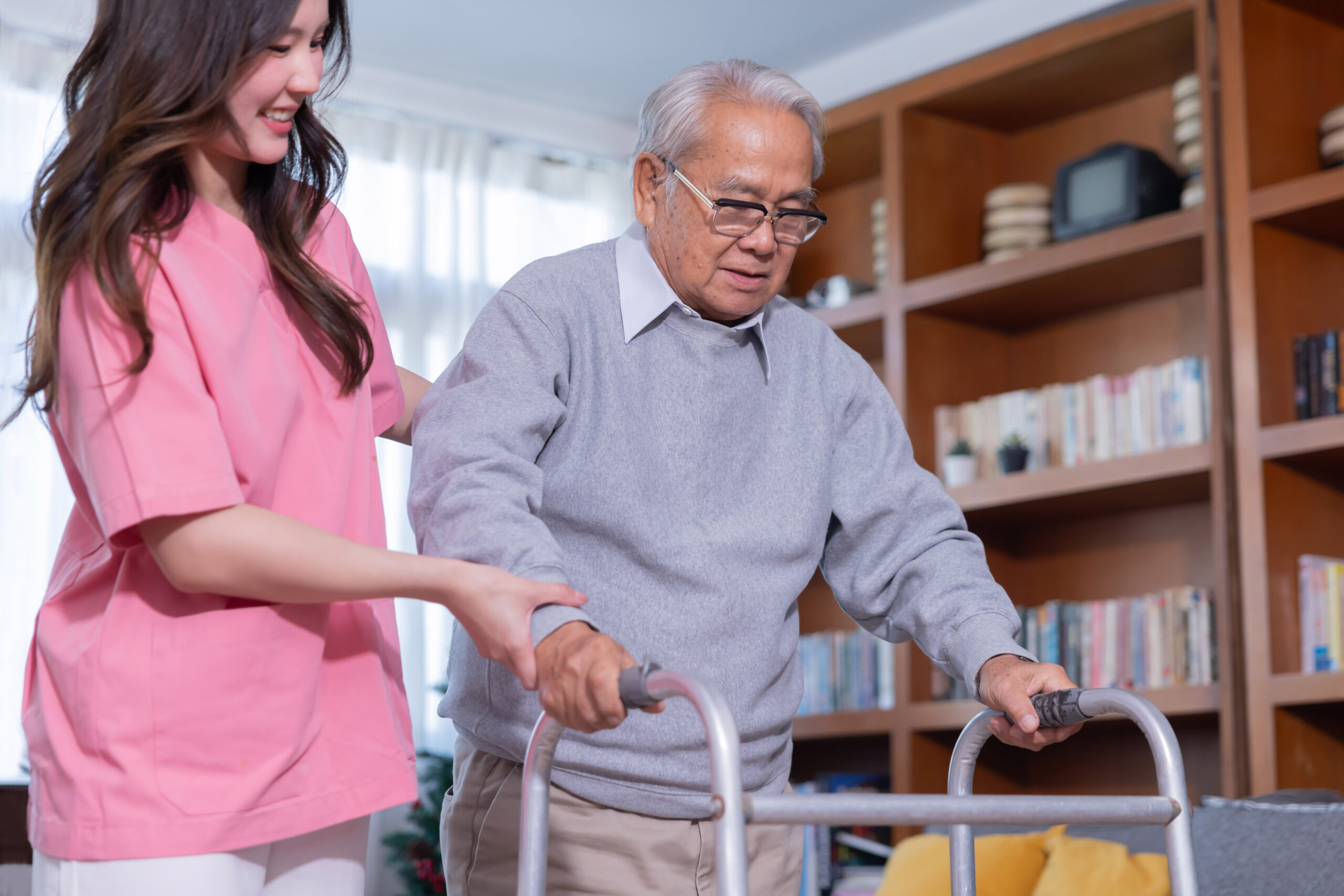 A young woman assists an elderly woman using a walker in a room Personal Home Care Bryant AR with in home personal care Bryant AR provided by a trusted personal care aide Bryant AR supporting seniors at home